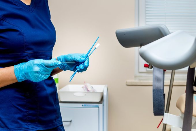 gynecologist holds instruments for taking pap smear test from a woman
