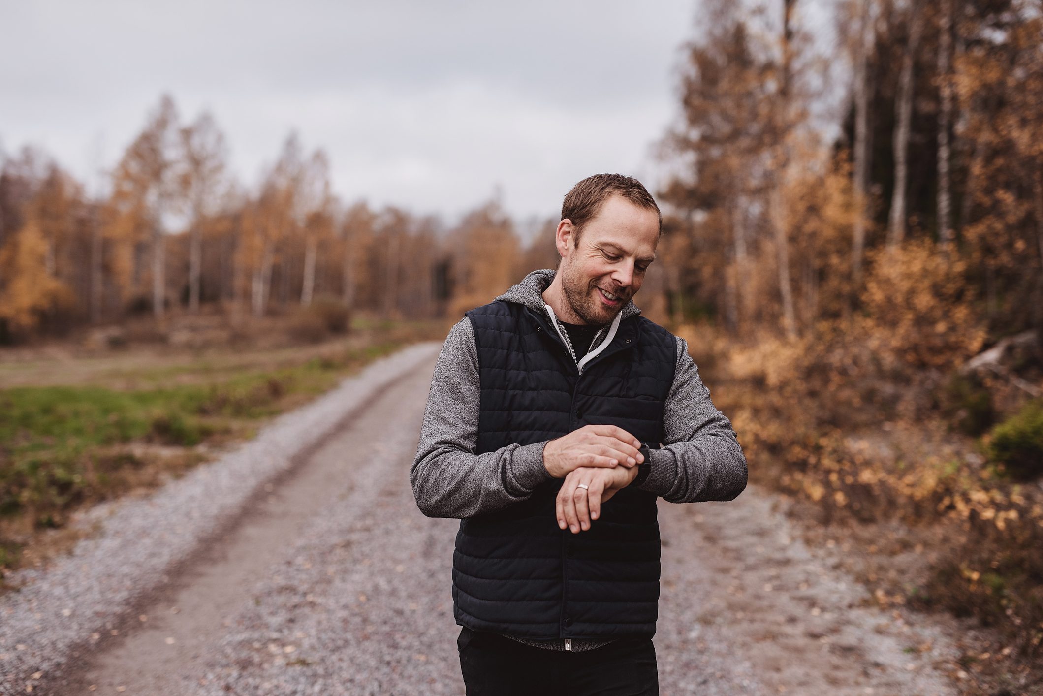 Man looking at smart fitness watch outdoors while walking