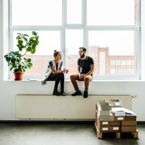 Young start up business people sitting in a window and talking