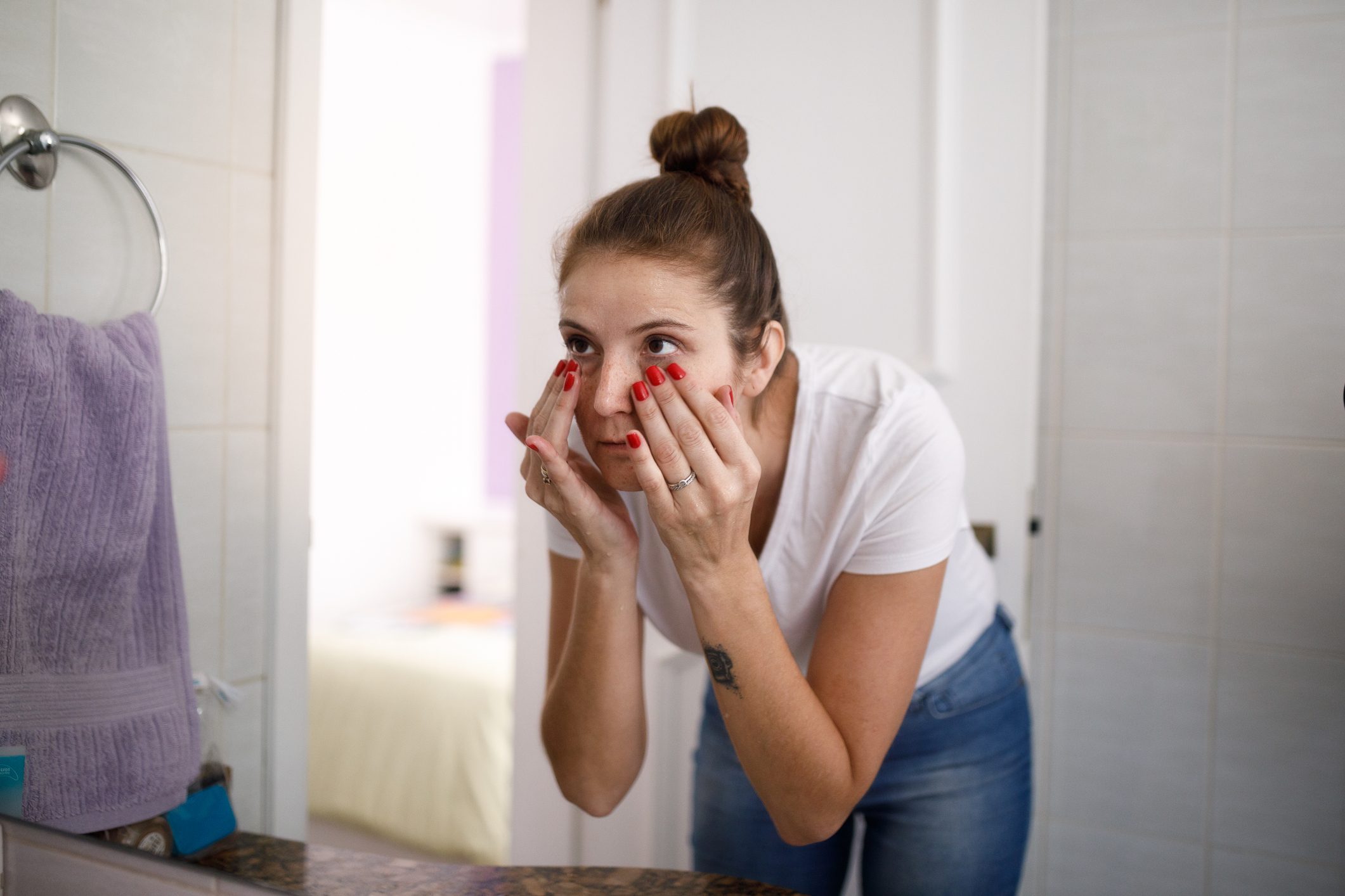 Young woman doing skin care at bathroom