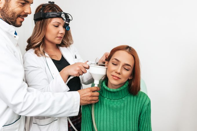 two doctors performing ear wax removal through irrigation