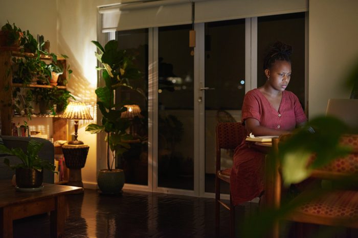 young woman working on computer at night
