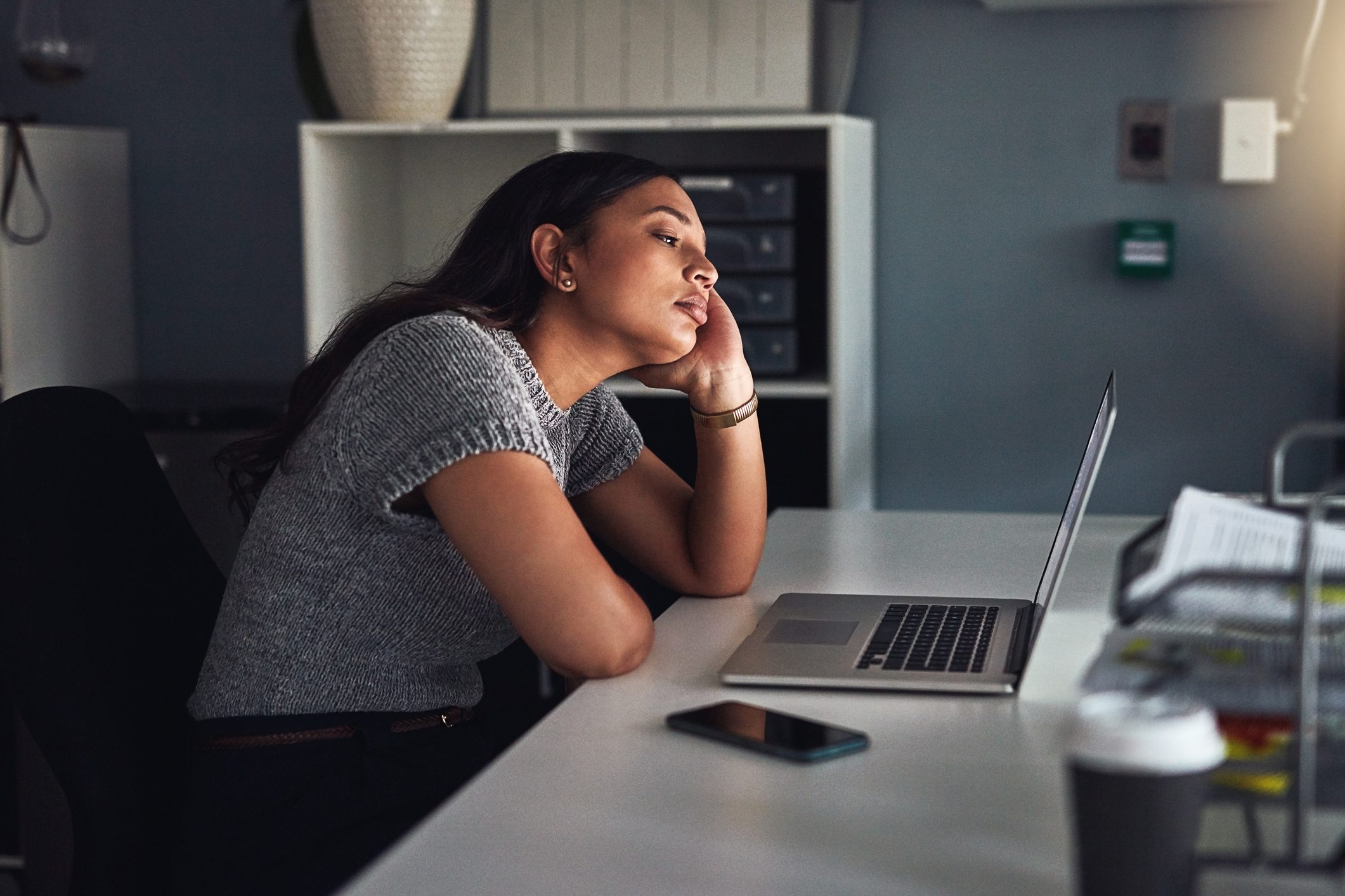 young woman procrastinating work on computer