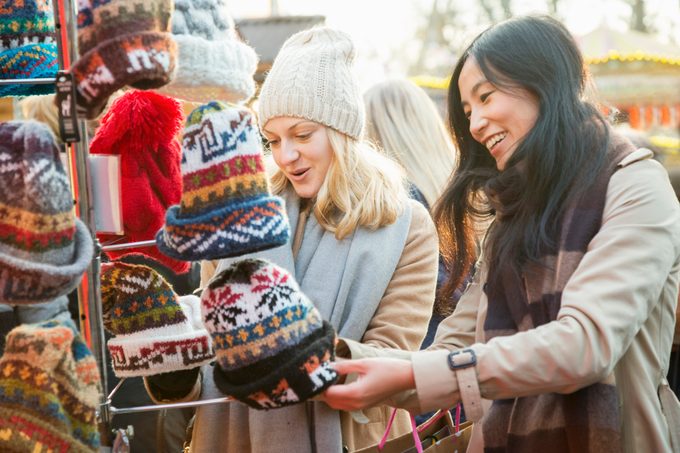 two friends looking at hats at the christmas market