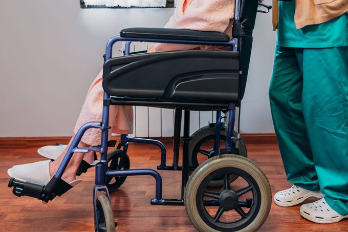 Doctor carrying elderly patient in a wheelchair