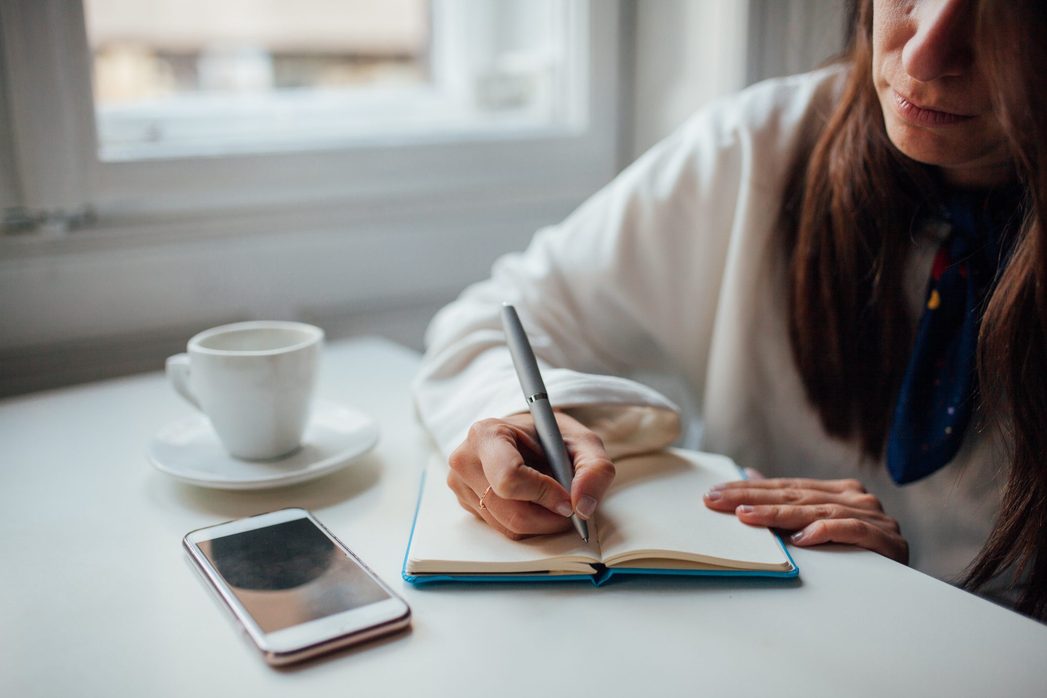 woman writing in notebook at home