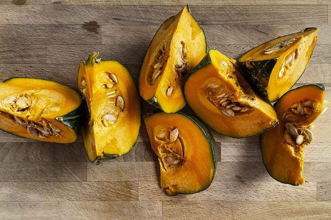 Sliced kabocha squash on wooden cutting board