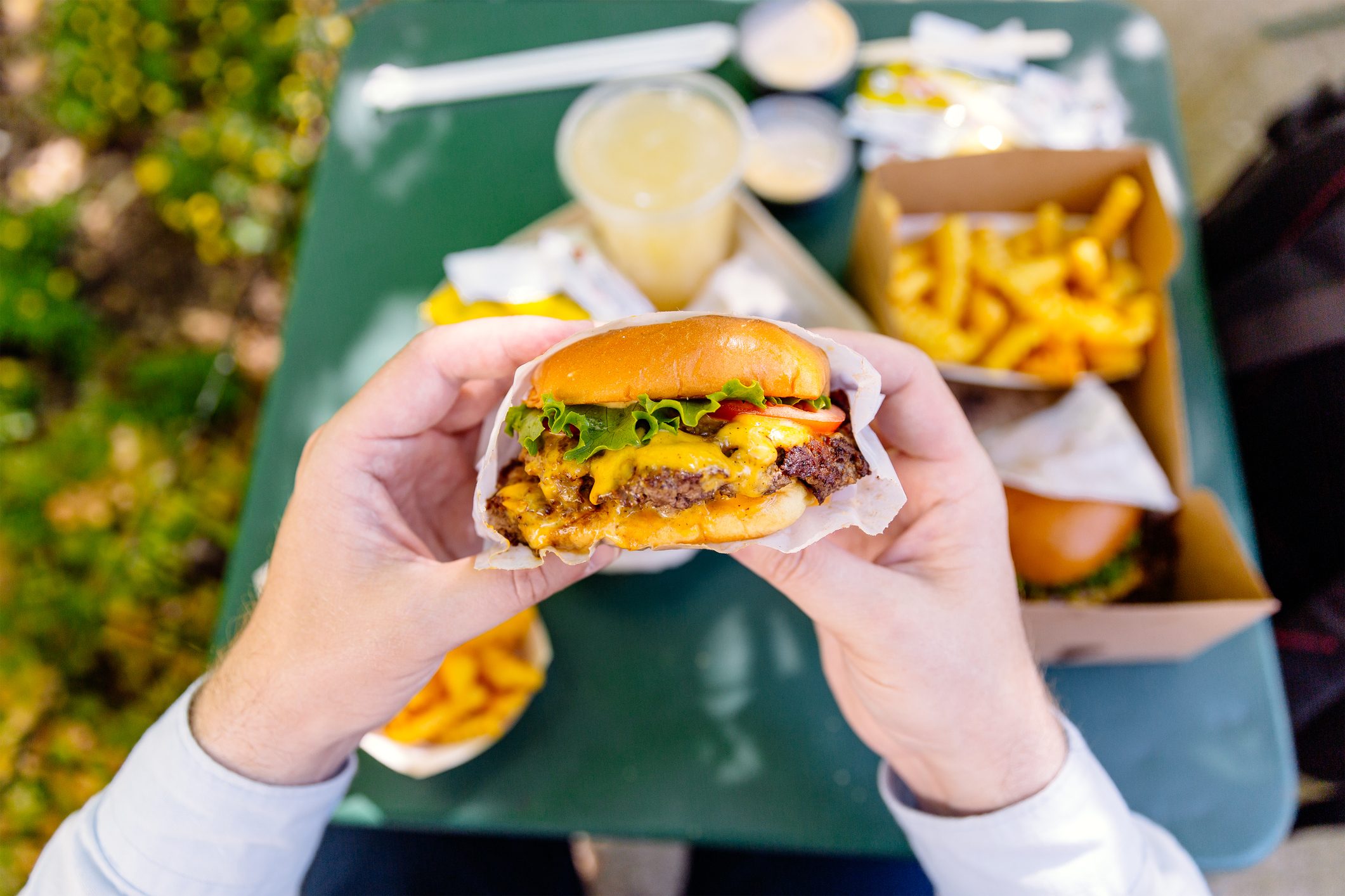 Man eating cheeseburger, personal perspective view