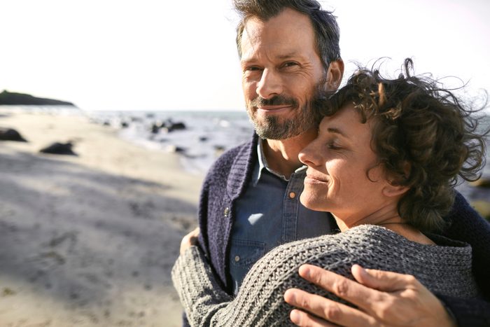 Portrait of smiling mature couple embracing on the beach