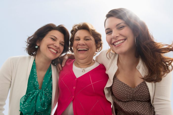 Three generations of women smiling outdoors