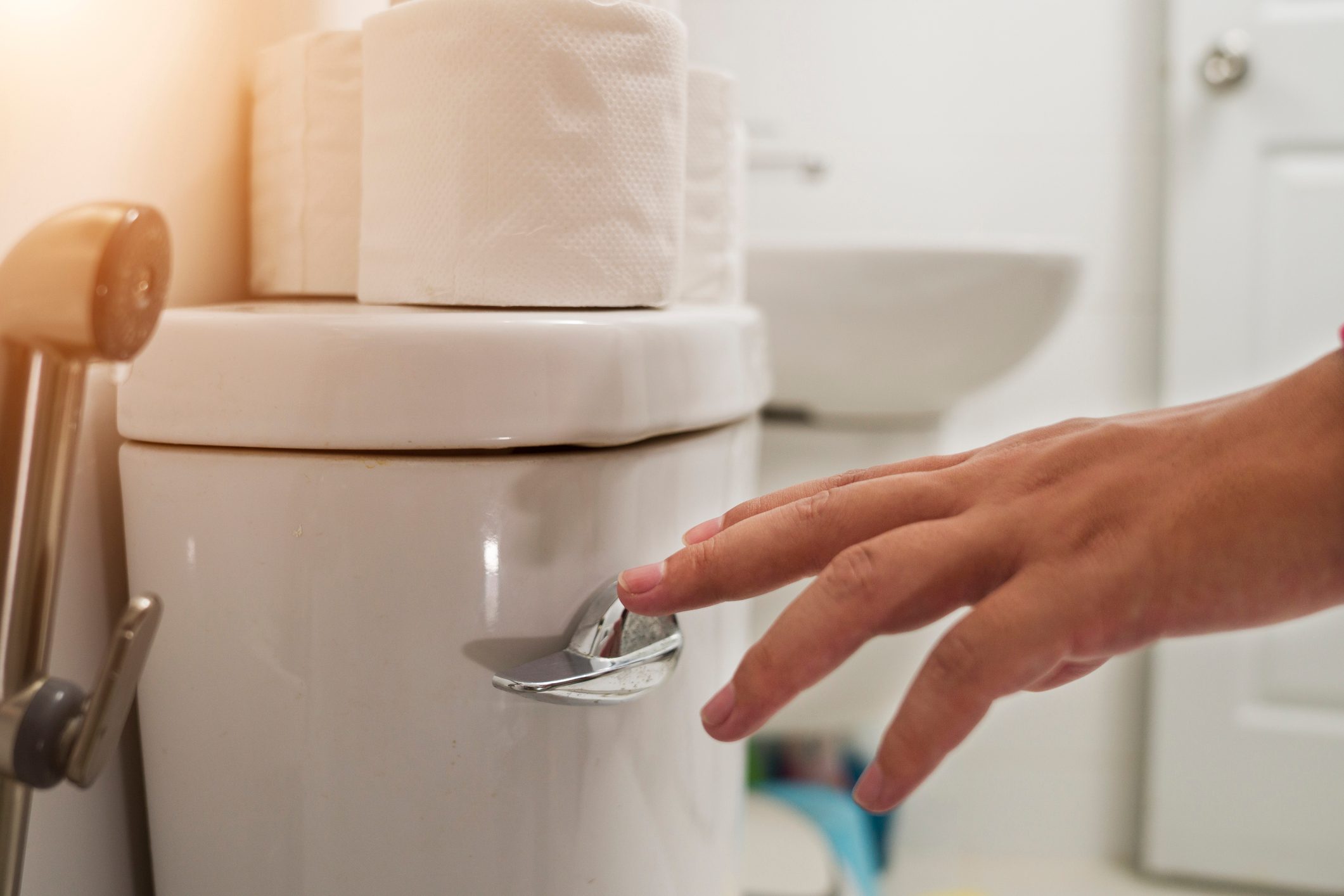 Cropped Hand Of Man Flushing toilet Water