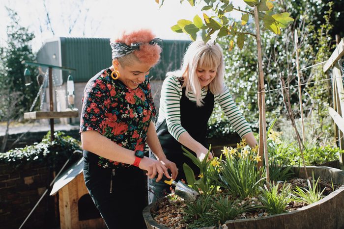 Two women at home gardening outdoors