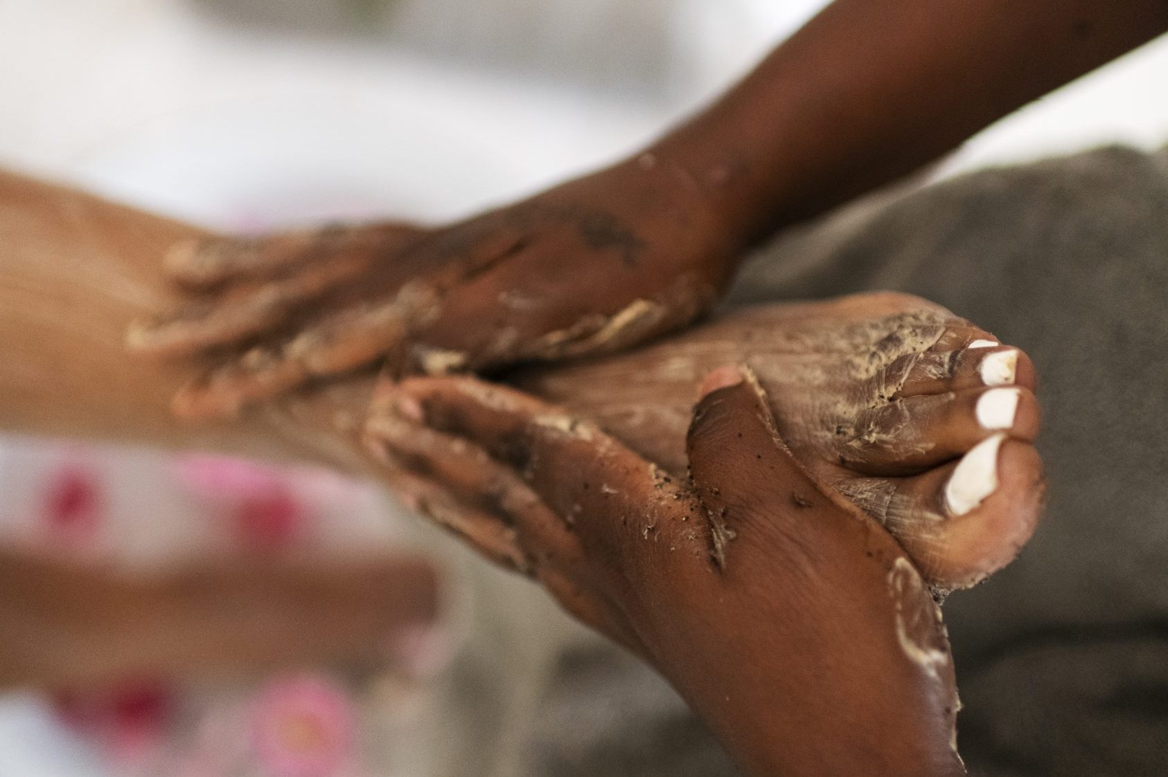 hands exfoliating feet in a spa