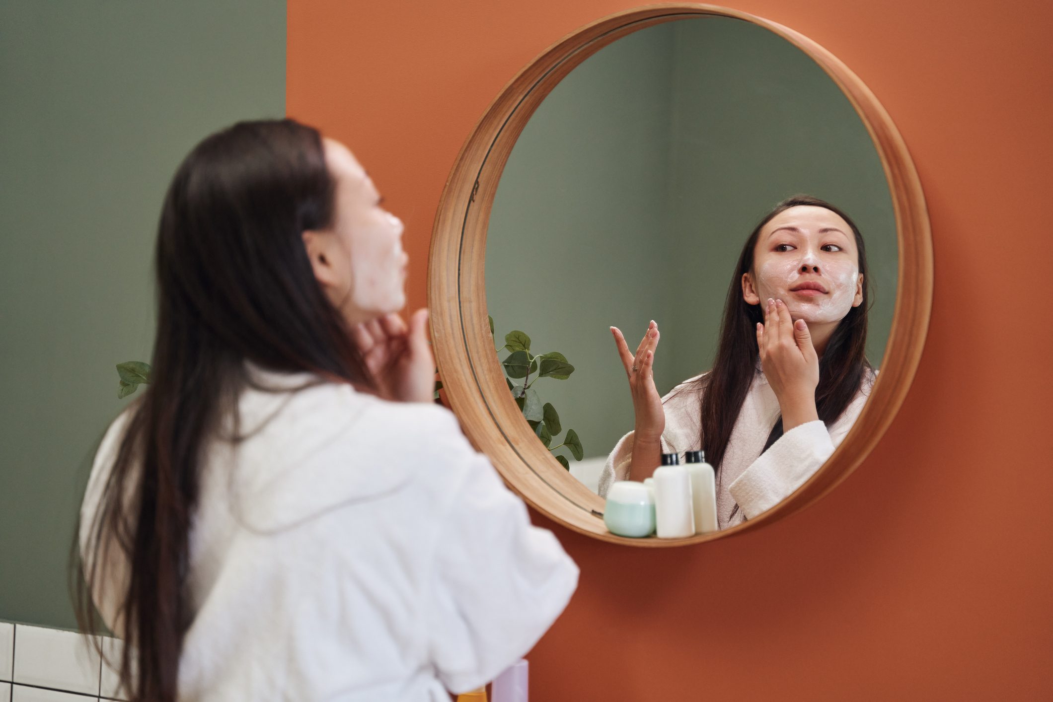 Asian woman applying moisture cream at her face