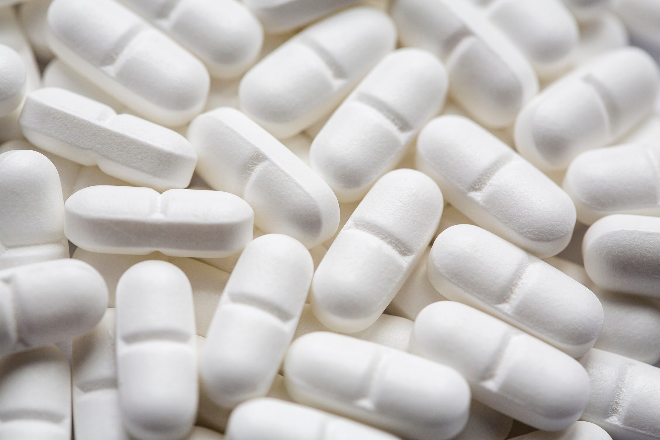 Pile of white magnesium pills, close up and full frame