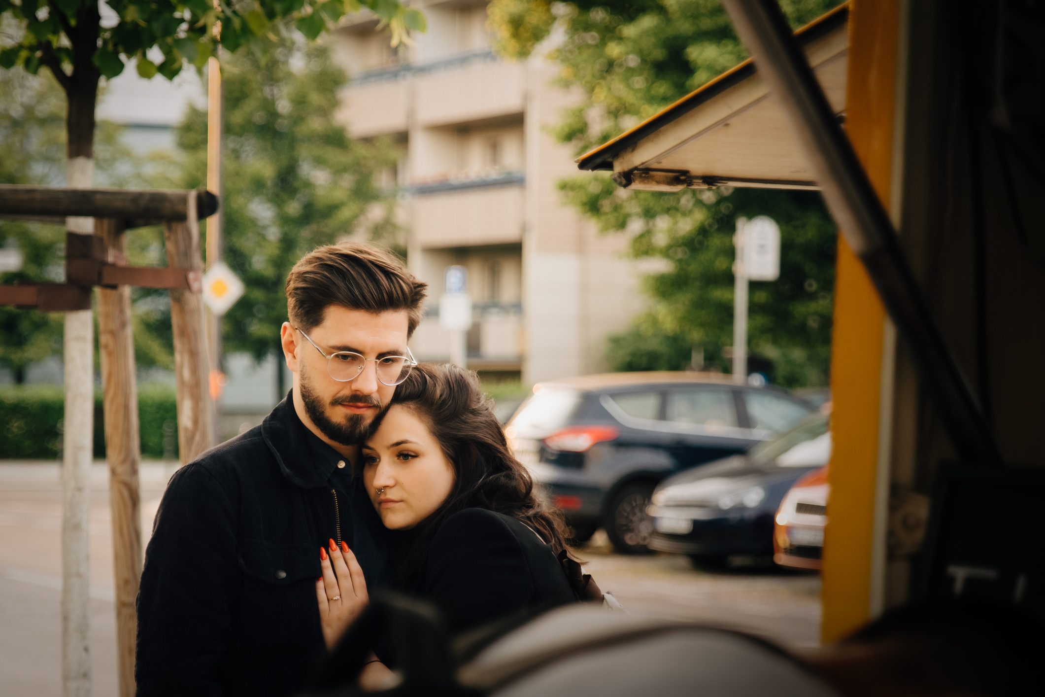 Man embracing sad woman while standing in city