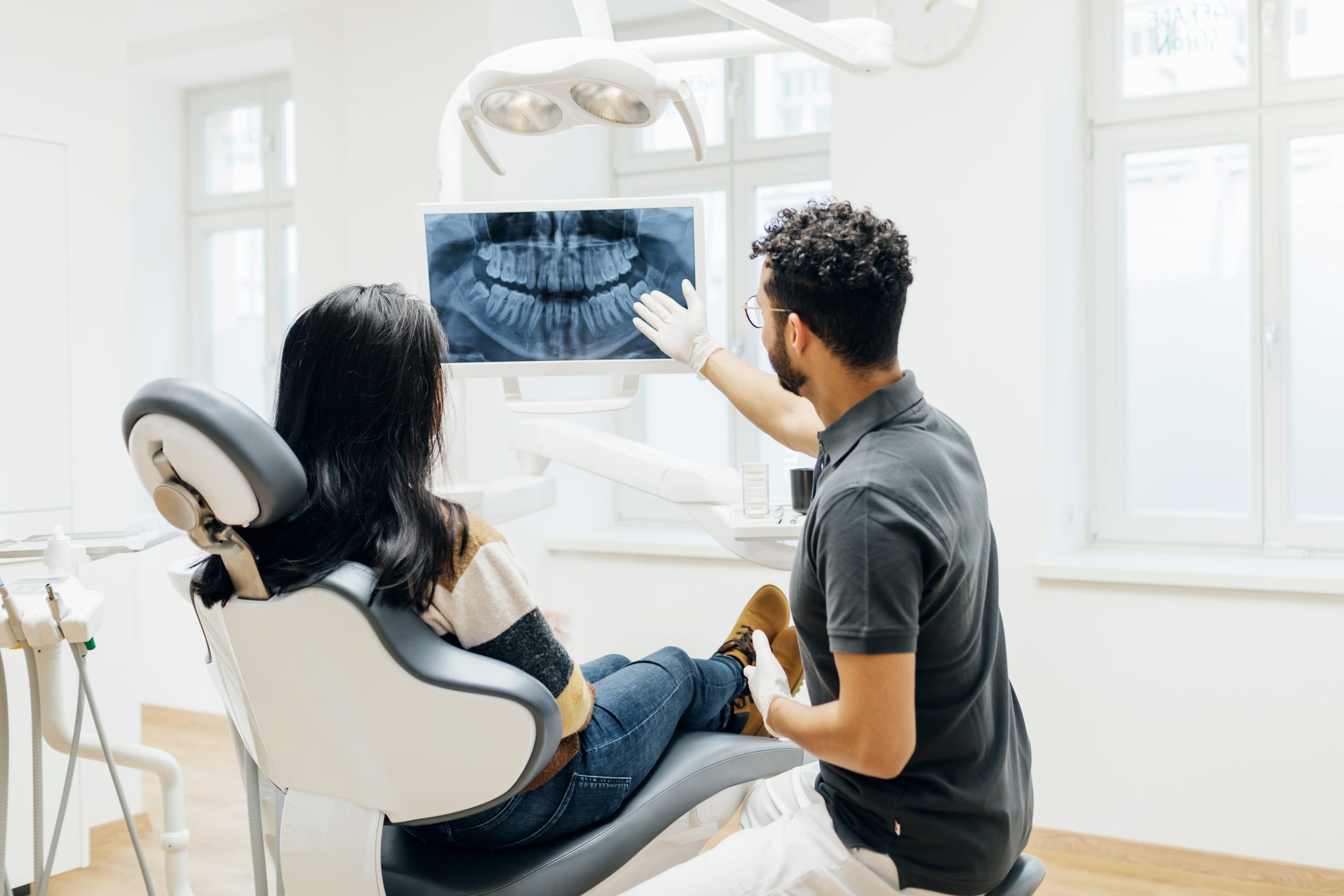 Dentist Showing Patient X-Ray Of Teeth After Check Up