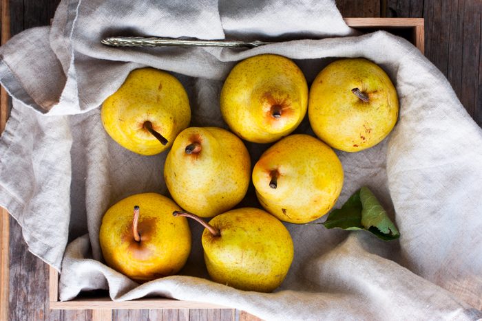 Chopped fresh yellow pear on a wooden board, top view, selective focus Fruit background.