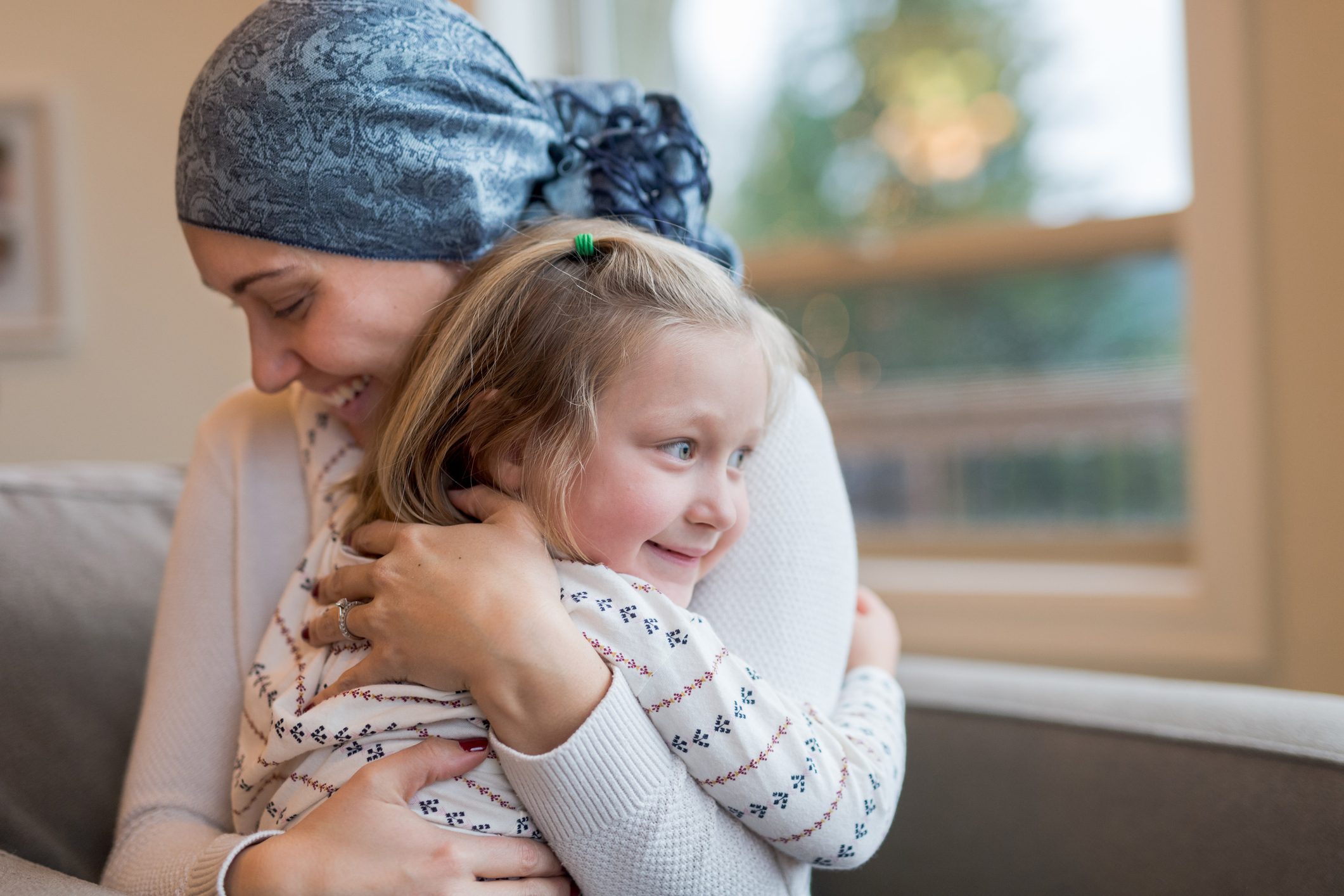 Young mom with cancer holds her daughter tightly