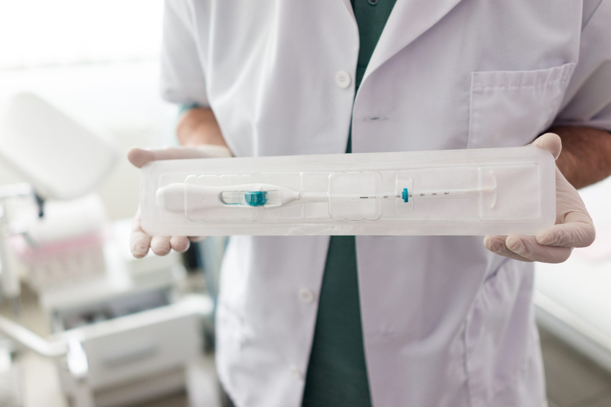 anonymous Doctor in hospital setting holding IUD