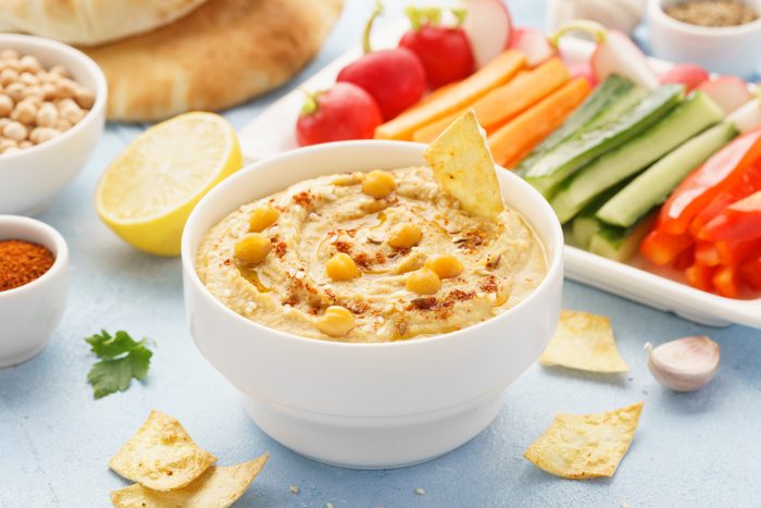 Hummus and variety of vegetable sticks and chips.
