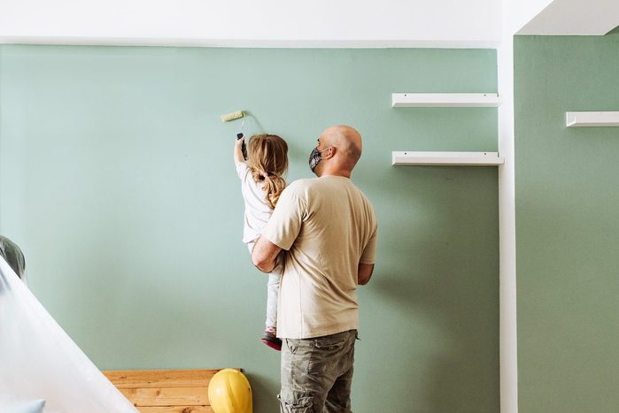 Teamwork in house renovation - daddy and daughter painting together