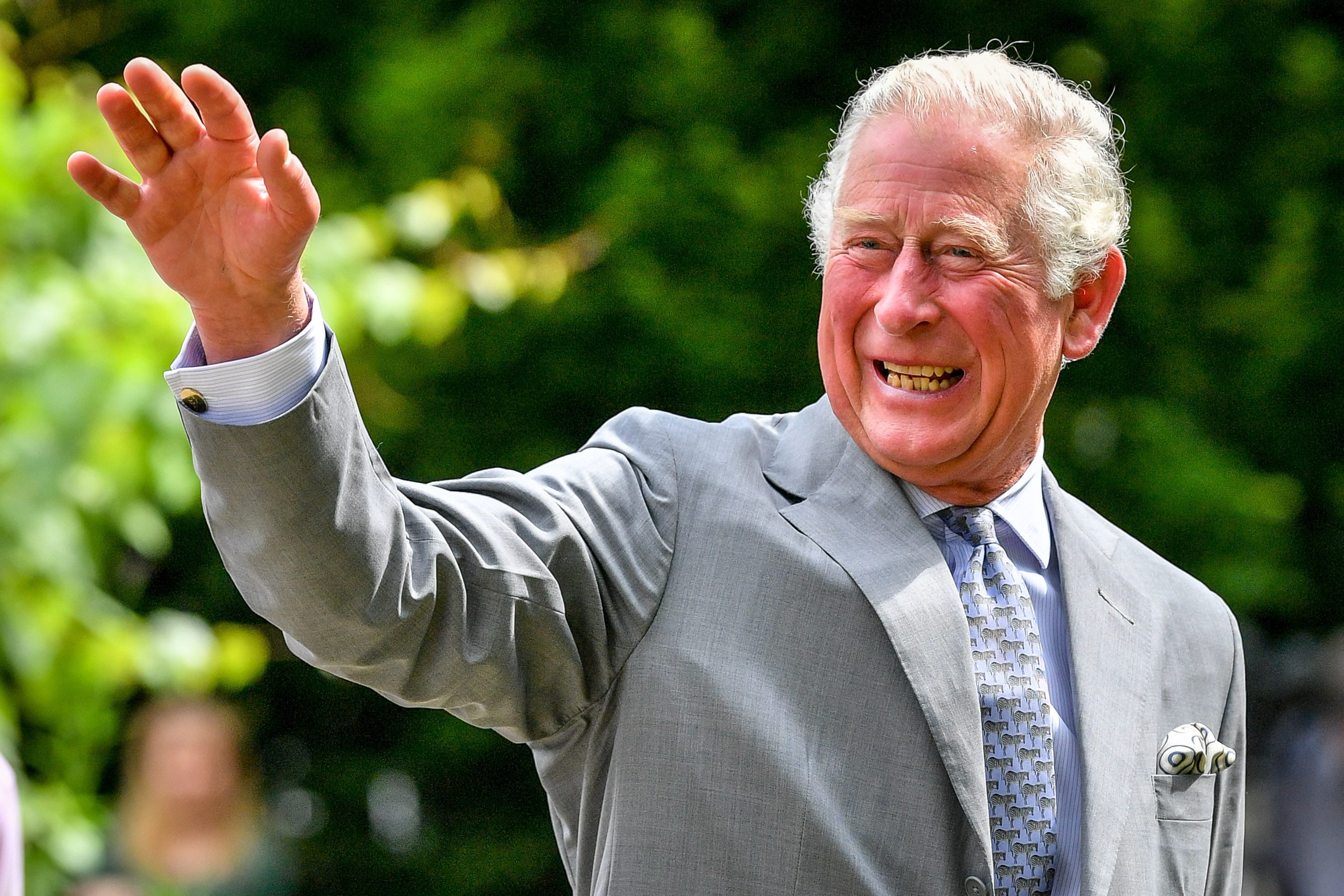 King Charles smiling and waving to someone