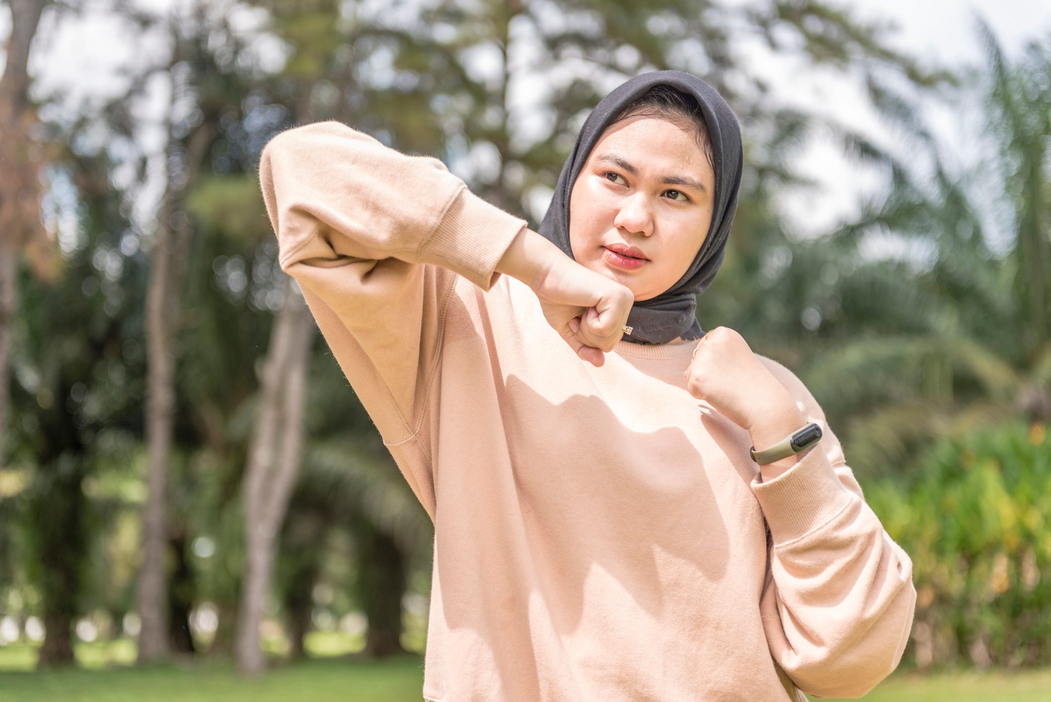 woman exercising in park practing elbow strike