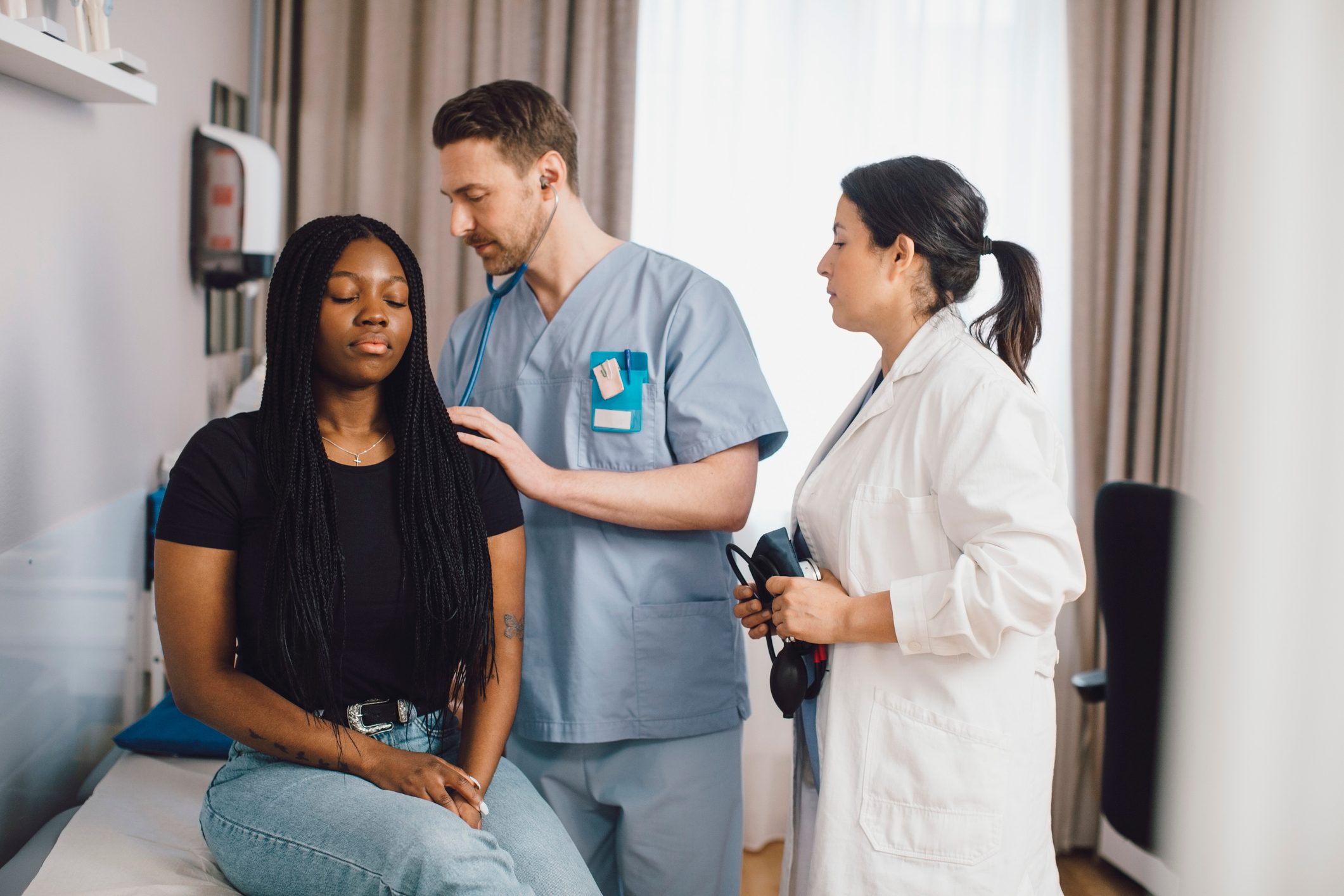 Mature male doctor checking patient in medical clinic