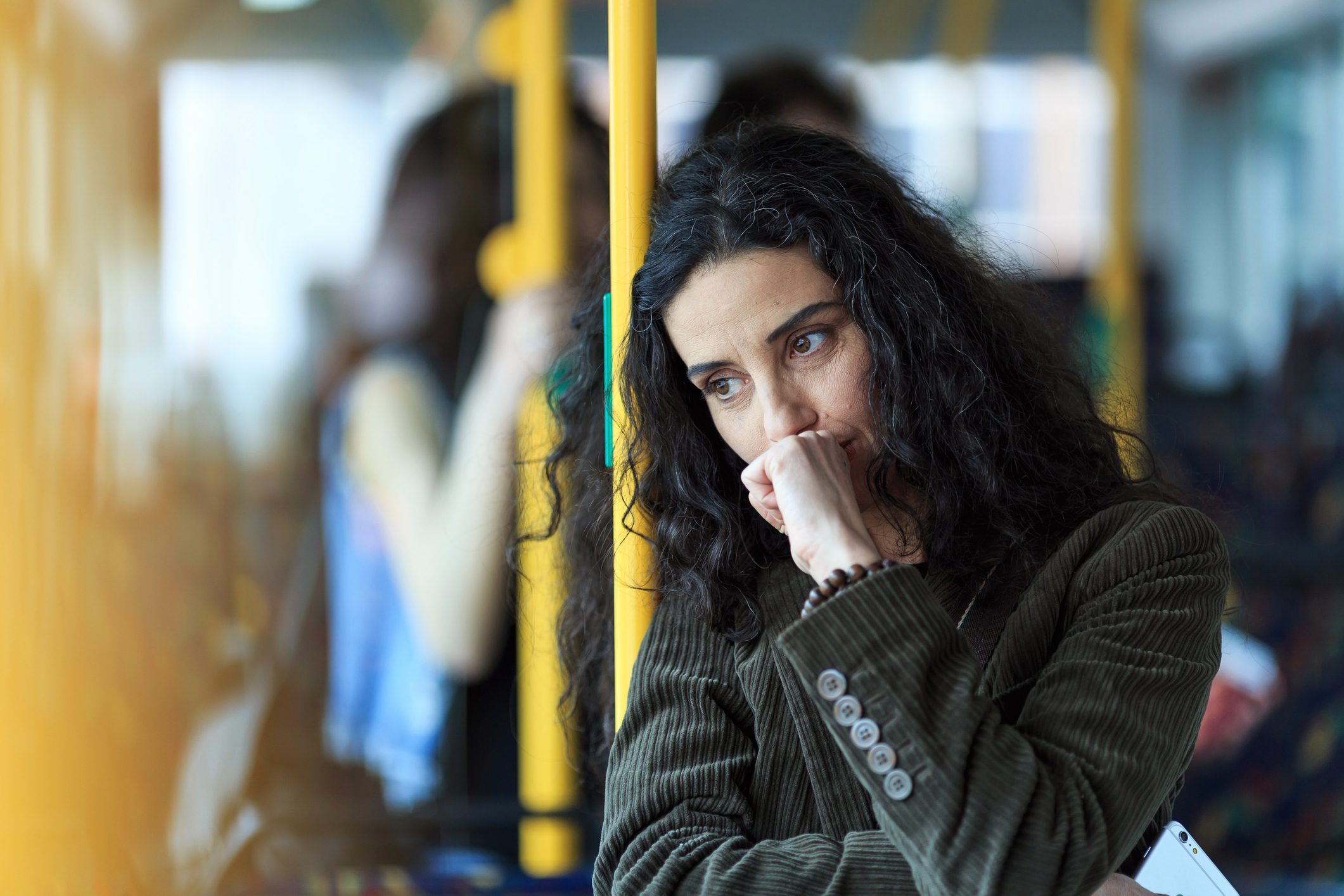 Pensive young woman traveling and holding smart phone