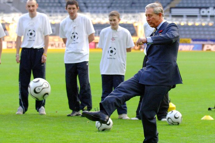 King Charles kicking a football or American soccer ball