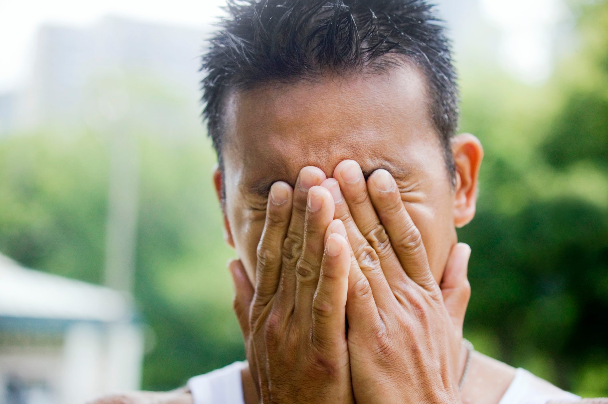 Man covering eyes in pain