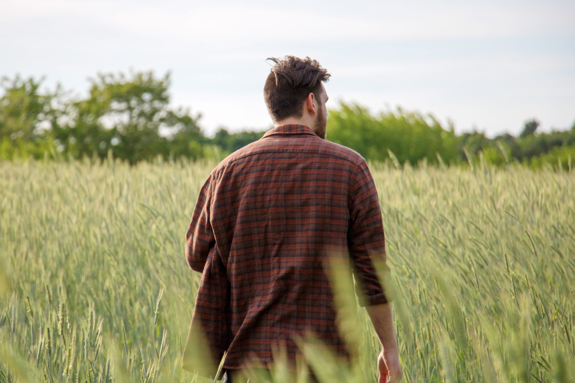 Rear View Of Young Man Walking On Field