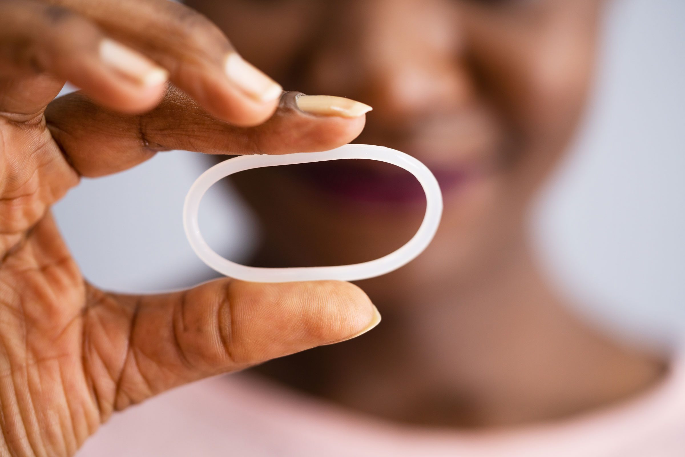 close up of a hand holding a vaginal ring for birth control