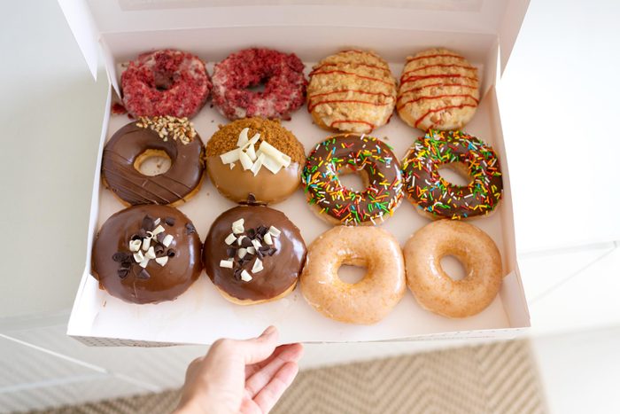 hand opening a donut box