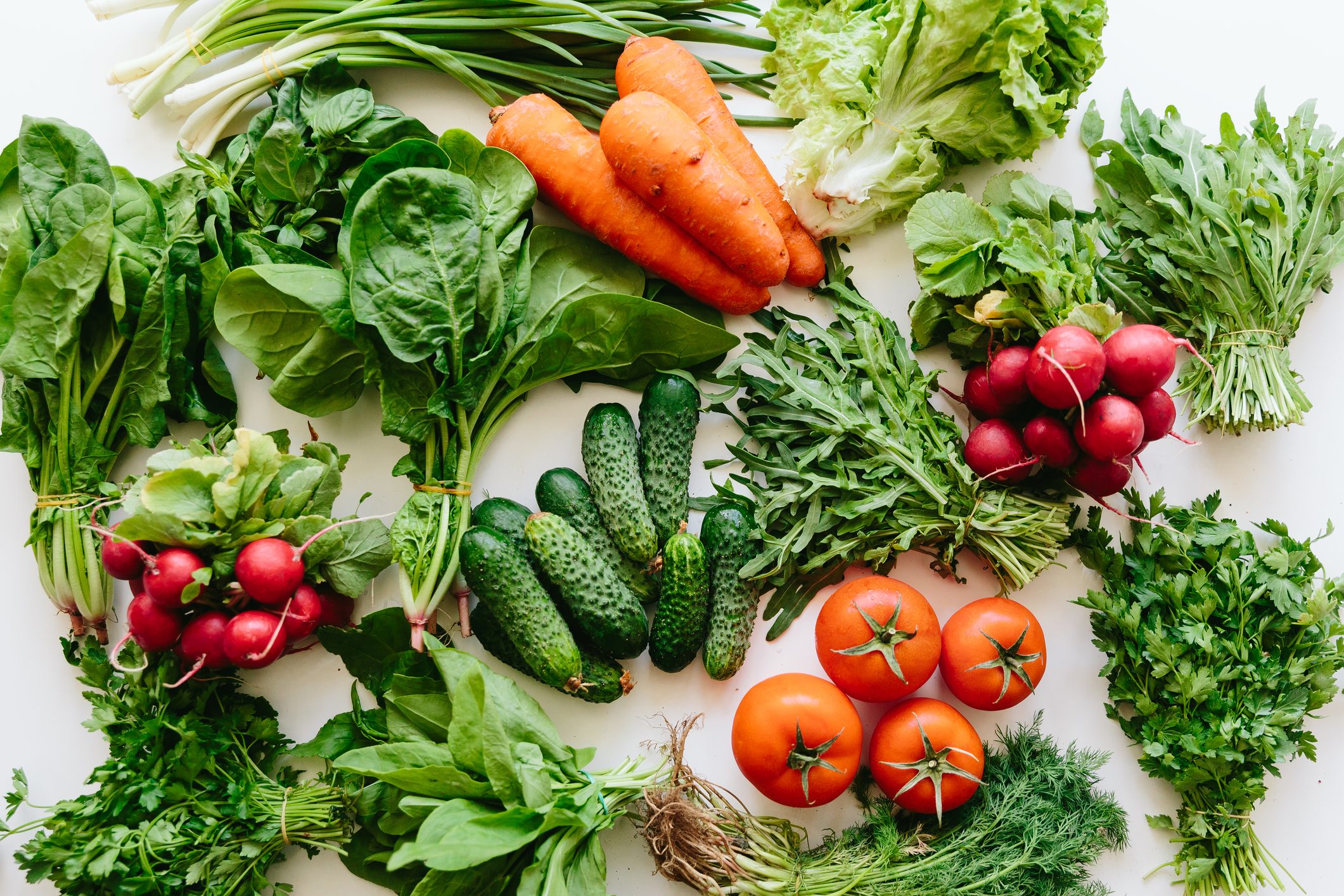 Fresh greens and vegetables on a table, high angle view