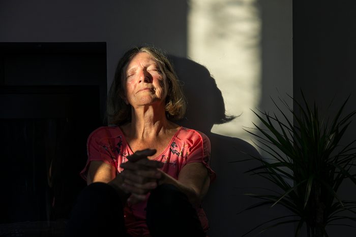 Senior lady catching the last of the sun's rays in her home