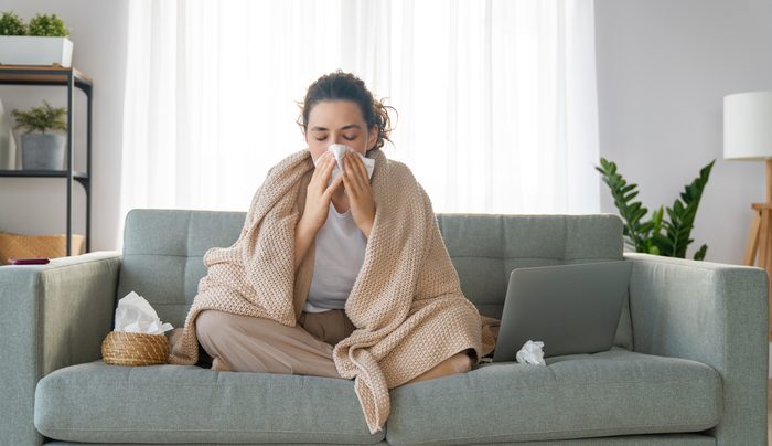 girl is holding paper tissue and blowing nose