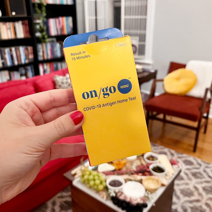 hand holding an On/Go at home covid test box