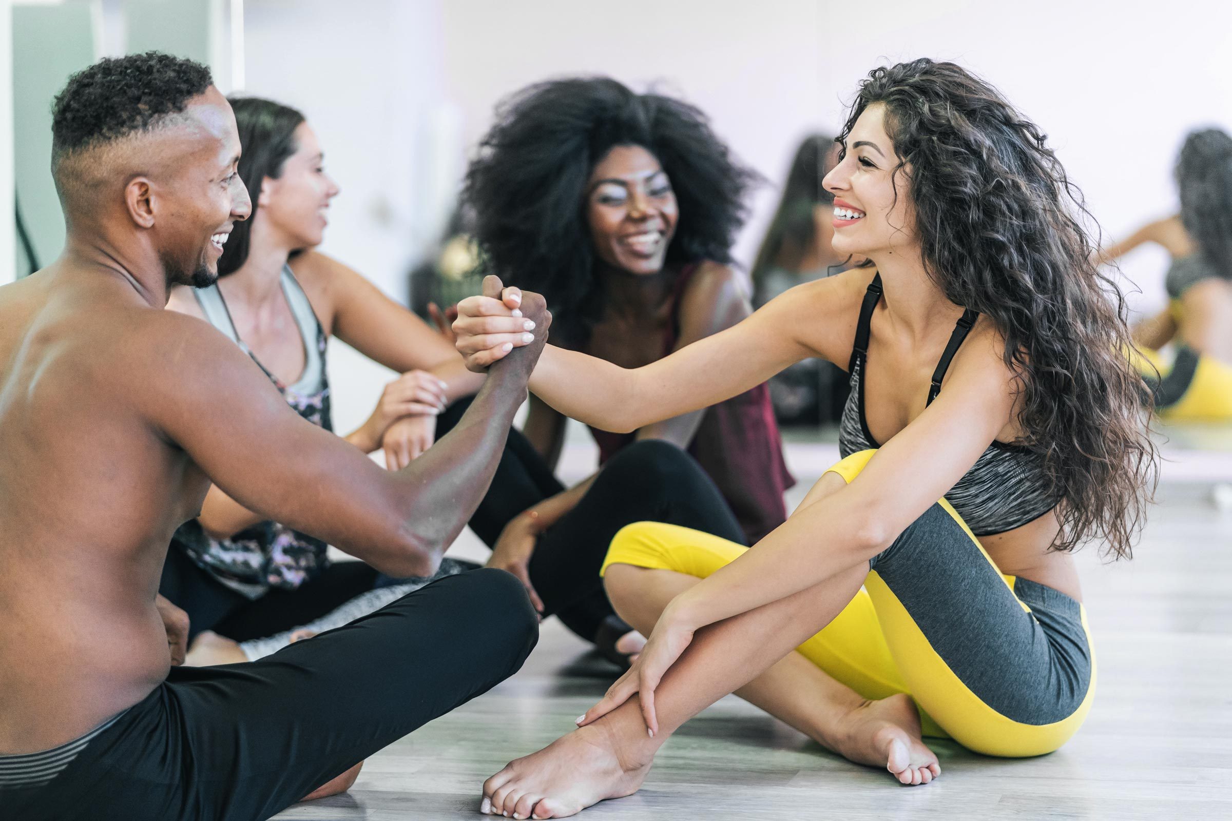 Group of dancers sitting on floor talking and rest