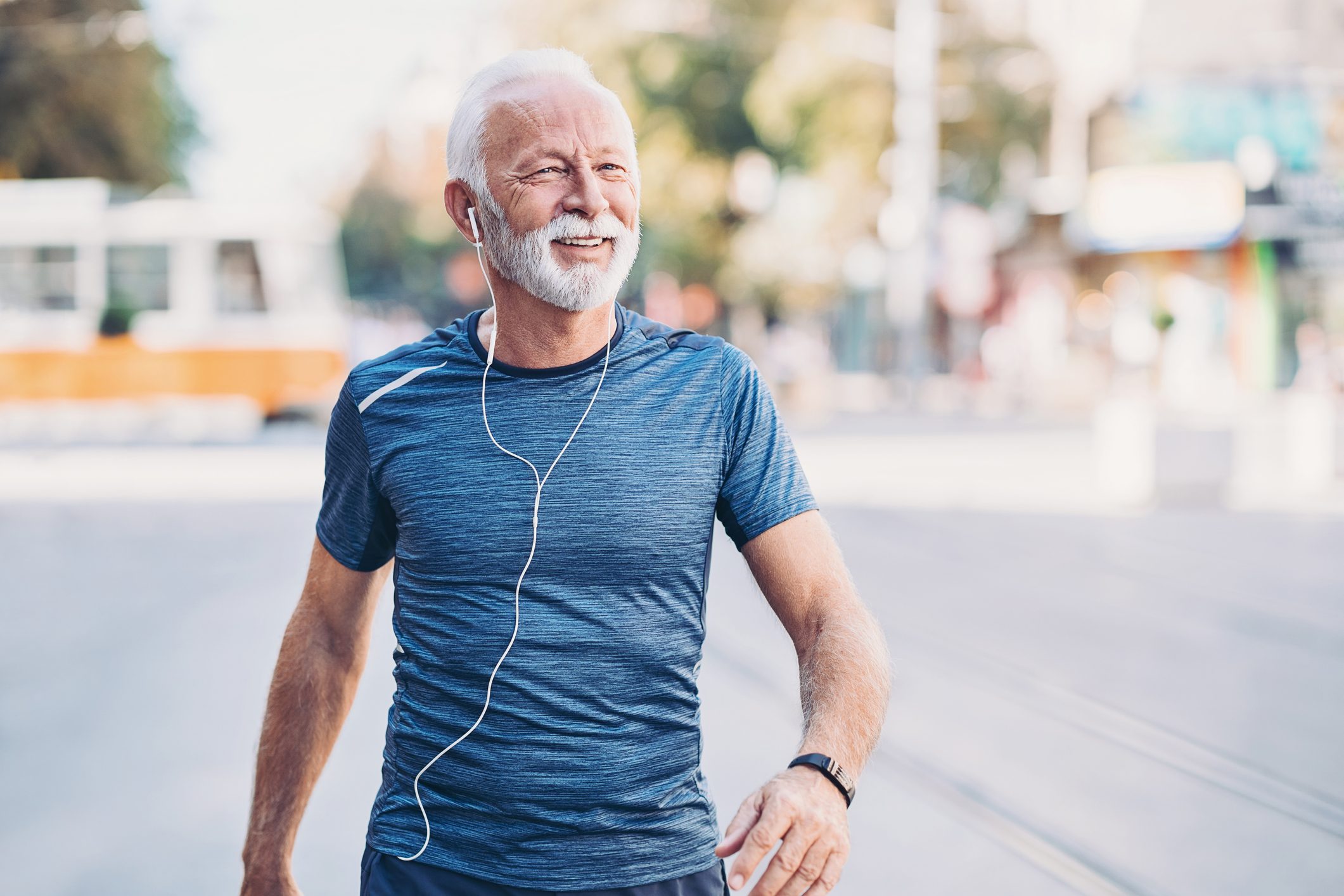 Smiling senior sportsman walking on the street