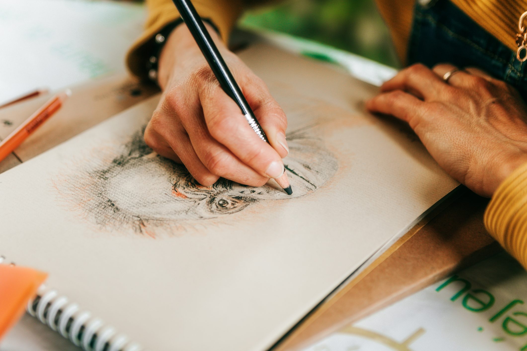 female artist drawing with colored pencils in her studio