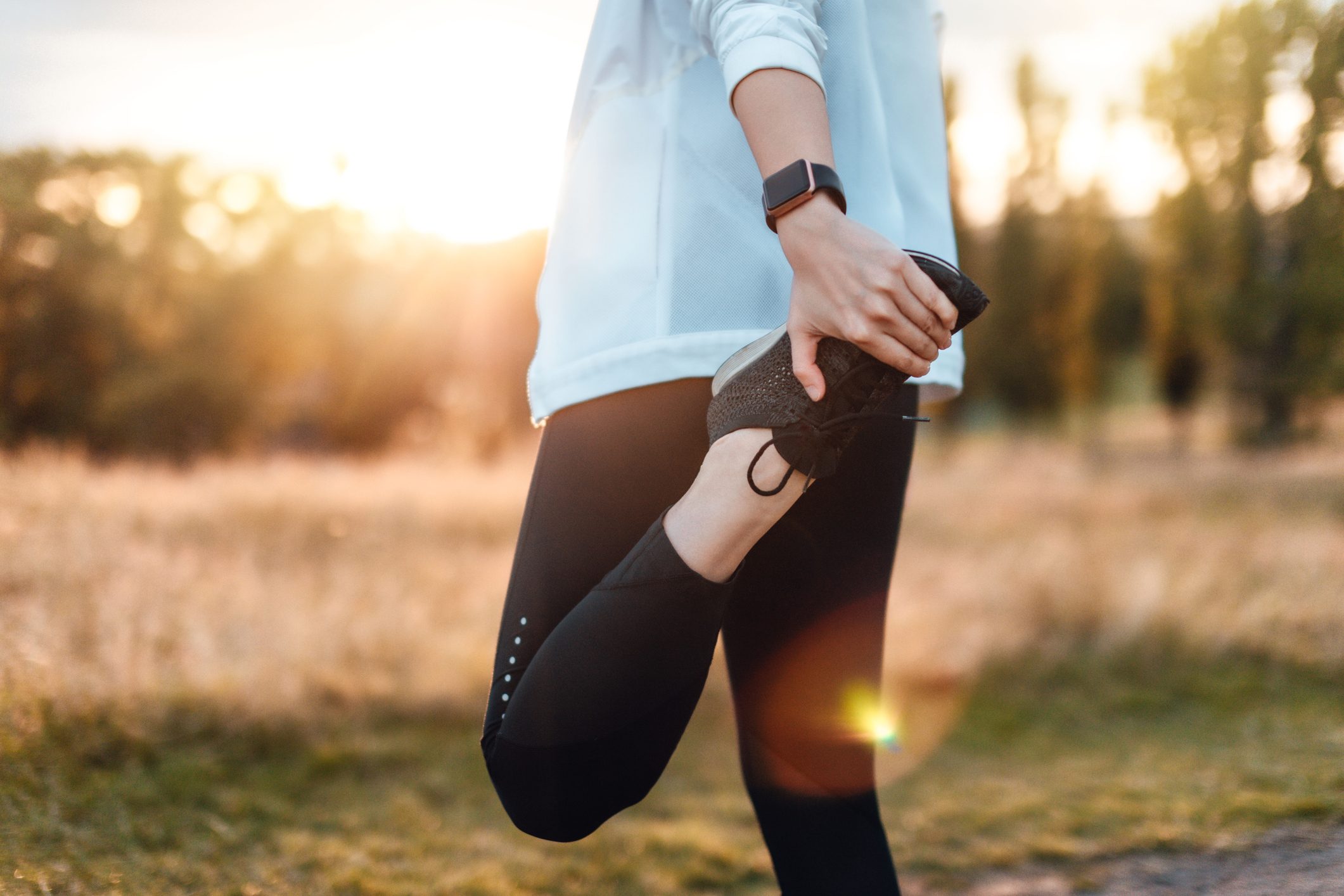 Young Woman Stretching Legs In The Park After Exercise