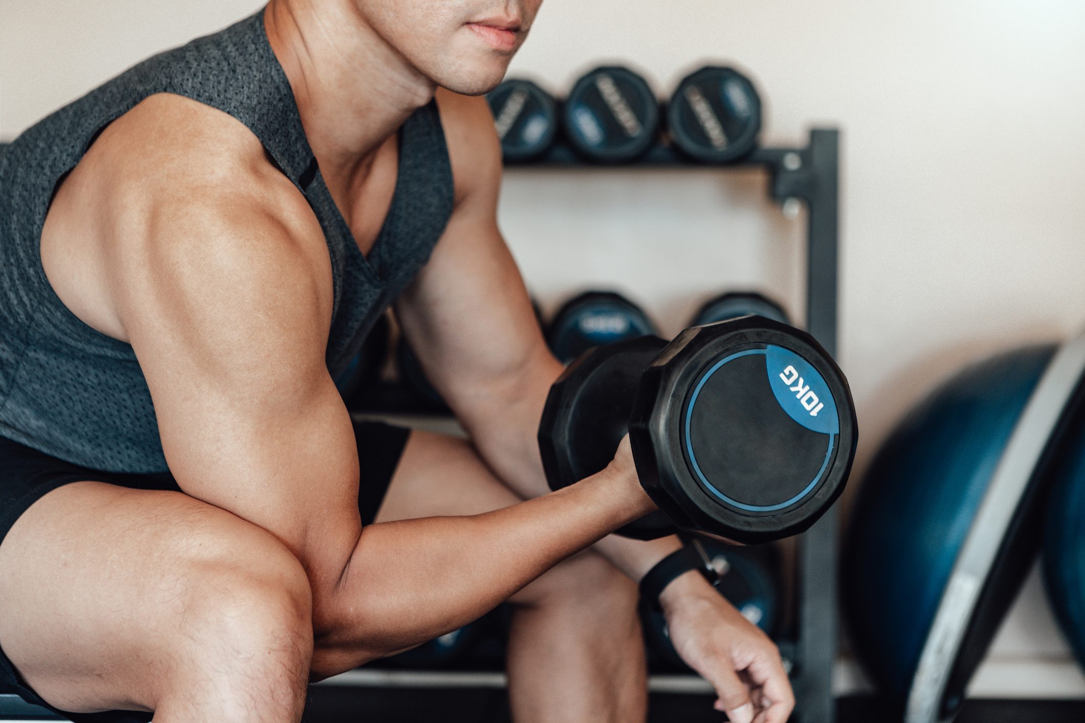 Muscular Young Man Training At Gym