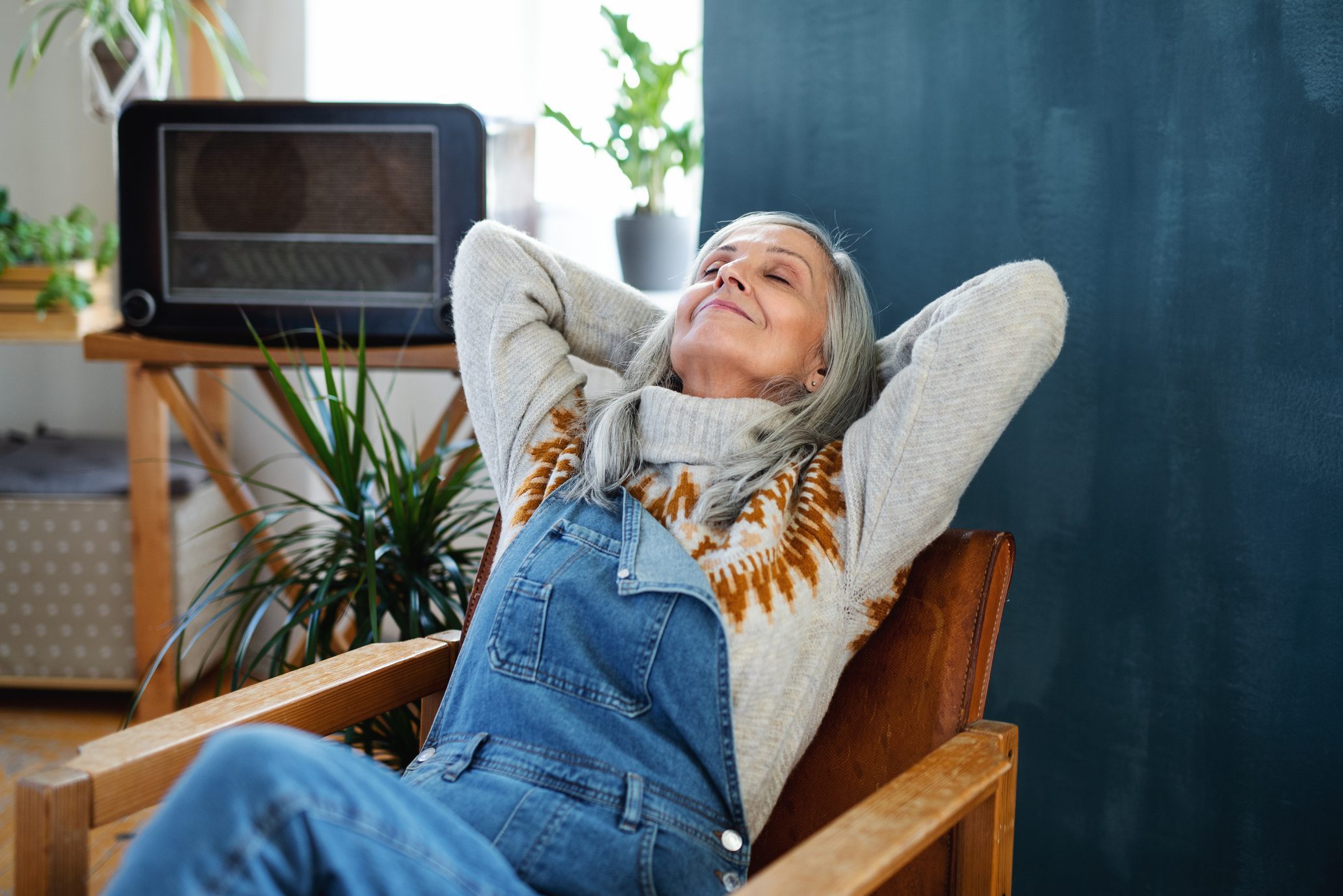 Senior woman sitting indoors at home, relaxing.