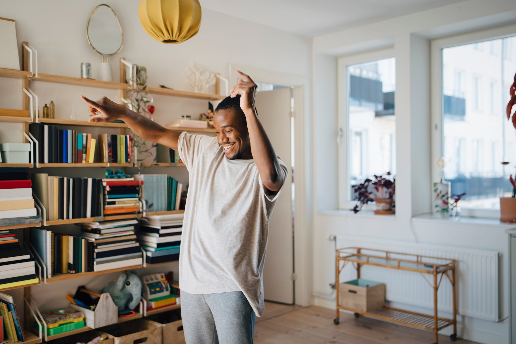 Happy man dancing in living room at home