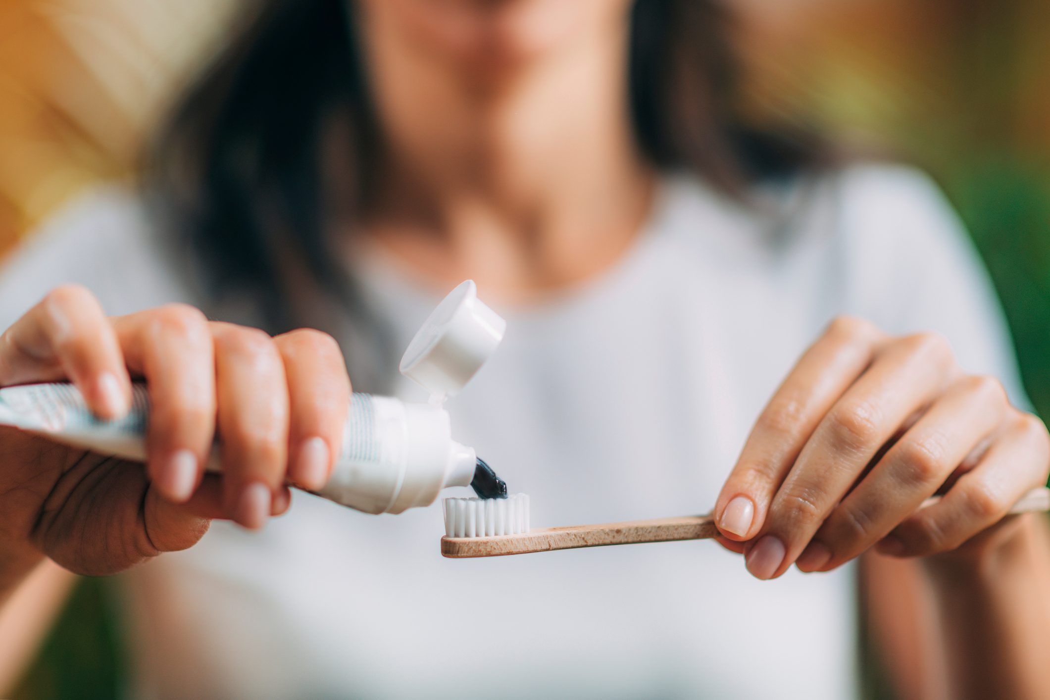 putting toothpaste onto a toothbrush 