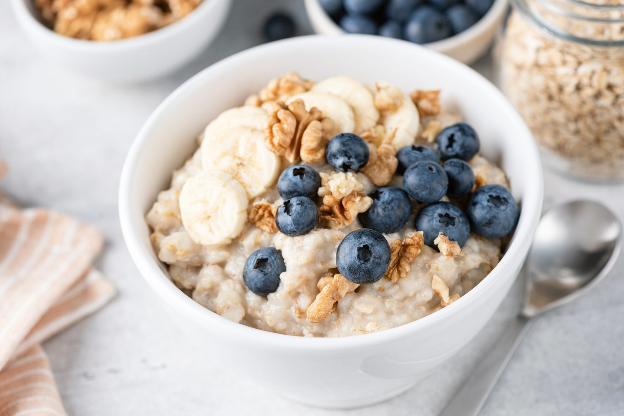 close up of bowl of Porridge oatmeal with banana blueberries and walnuts