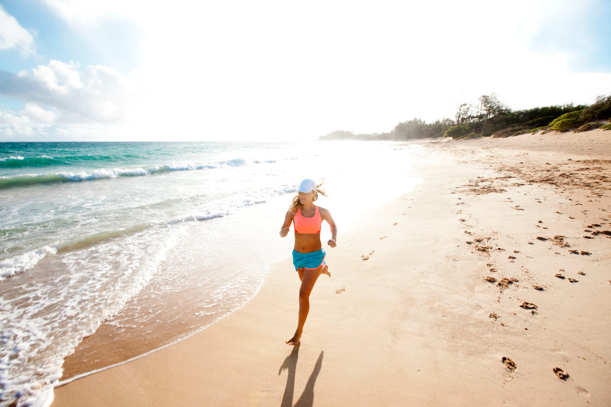 Female running on a sandy beach.