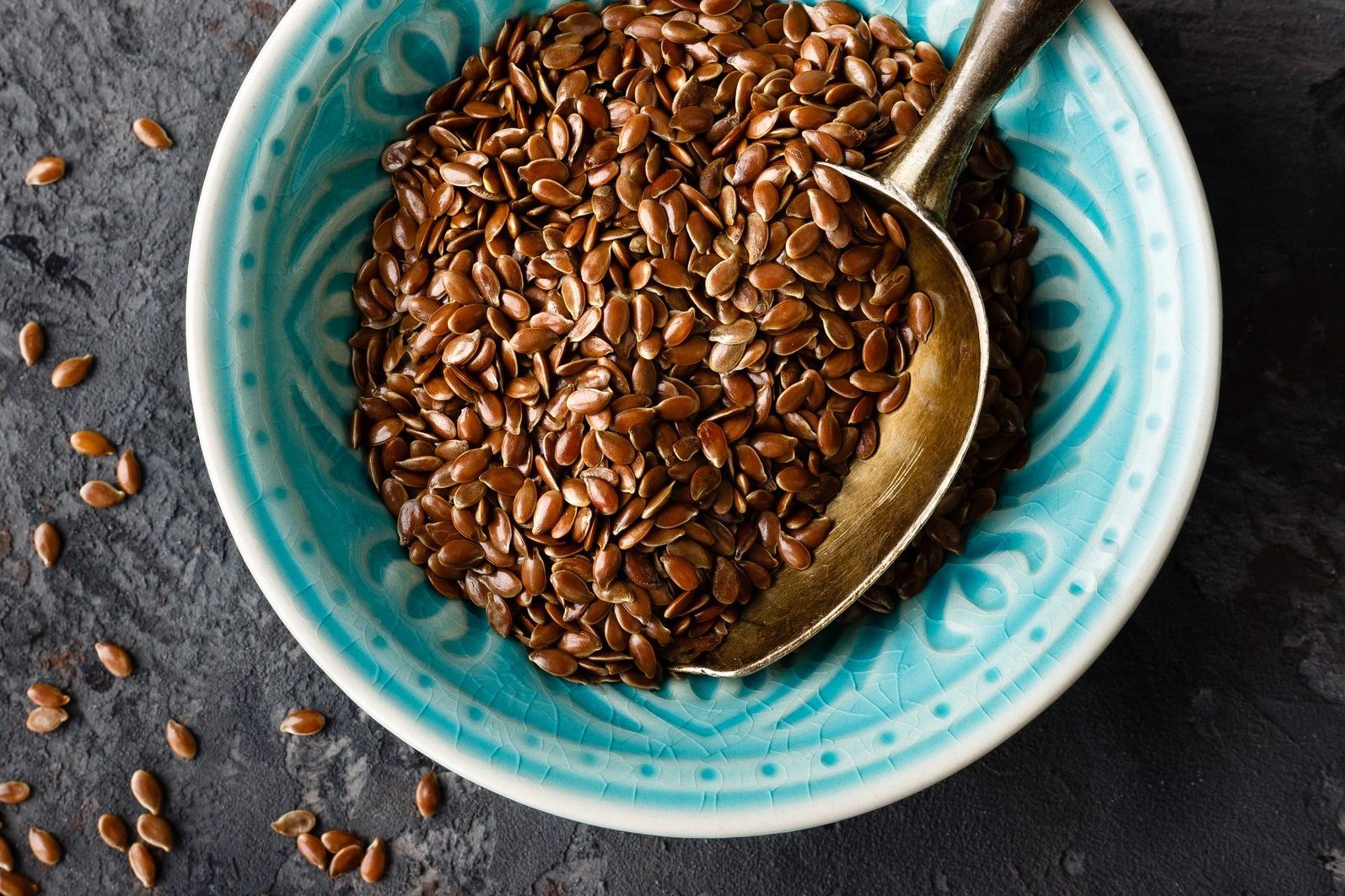 Flax seeds in bowl on dark background closeup top view